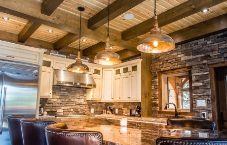 Kitchen with stone wall and cream cabinets