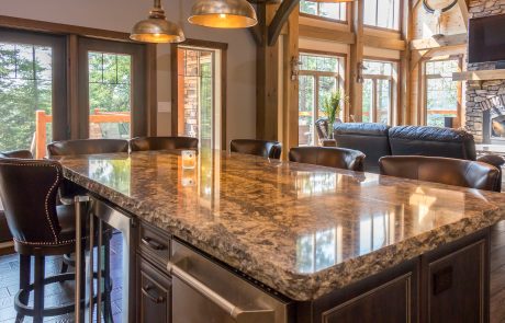 Kitchen island with dark cabinets and black/white stone countertop.
