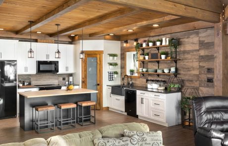 Kitchen with wood accent wall. White cabinets with black countertops.
