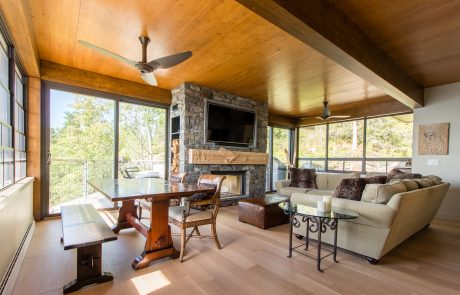 Living & dining area with stone fireplace and wood ceiling.