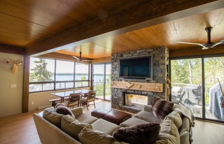 Living & dining area with stone fireplace and wood ceiling.