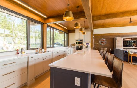 Kitchen with white cabinets and white countertops. Center island has dark blue cabinets.