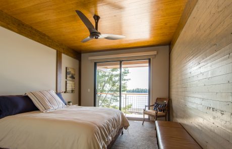 Bedroom with sliding doors leading out to the deck overlooking the lake.