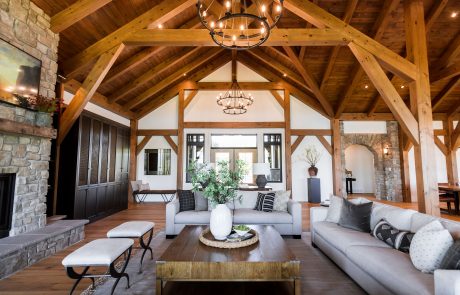 Family room with wood ceiling and beams. Stone arch accent wall and fireplace.