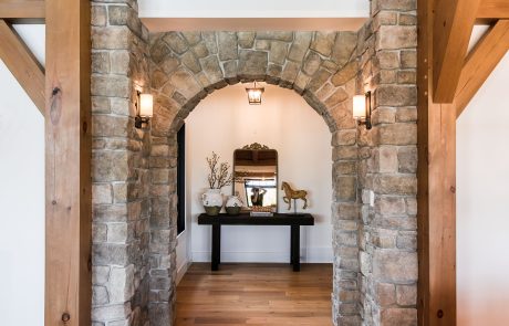 Stone arch accent wall leading into hallway