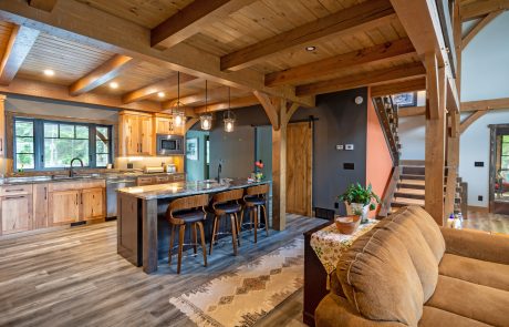 Kitchen with island seating for three. Wood floors and cabinets.