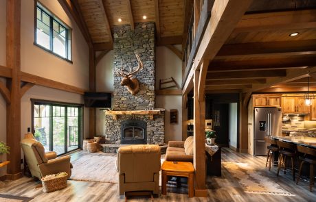 Living room and kitchen view. Large stone fireplace with Elk mount above the mantle.