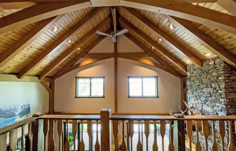 View from the loft area of the ceiling beams and railing from the second floor