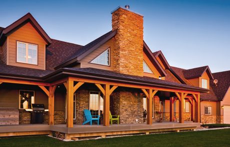Home exterior front porch with large stone fireplace chimney
