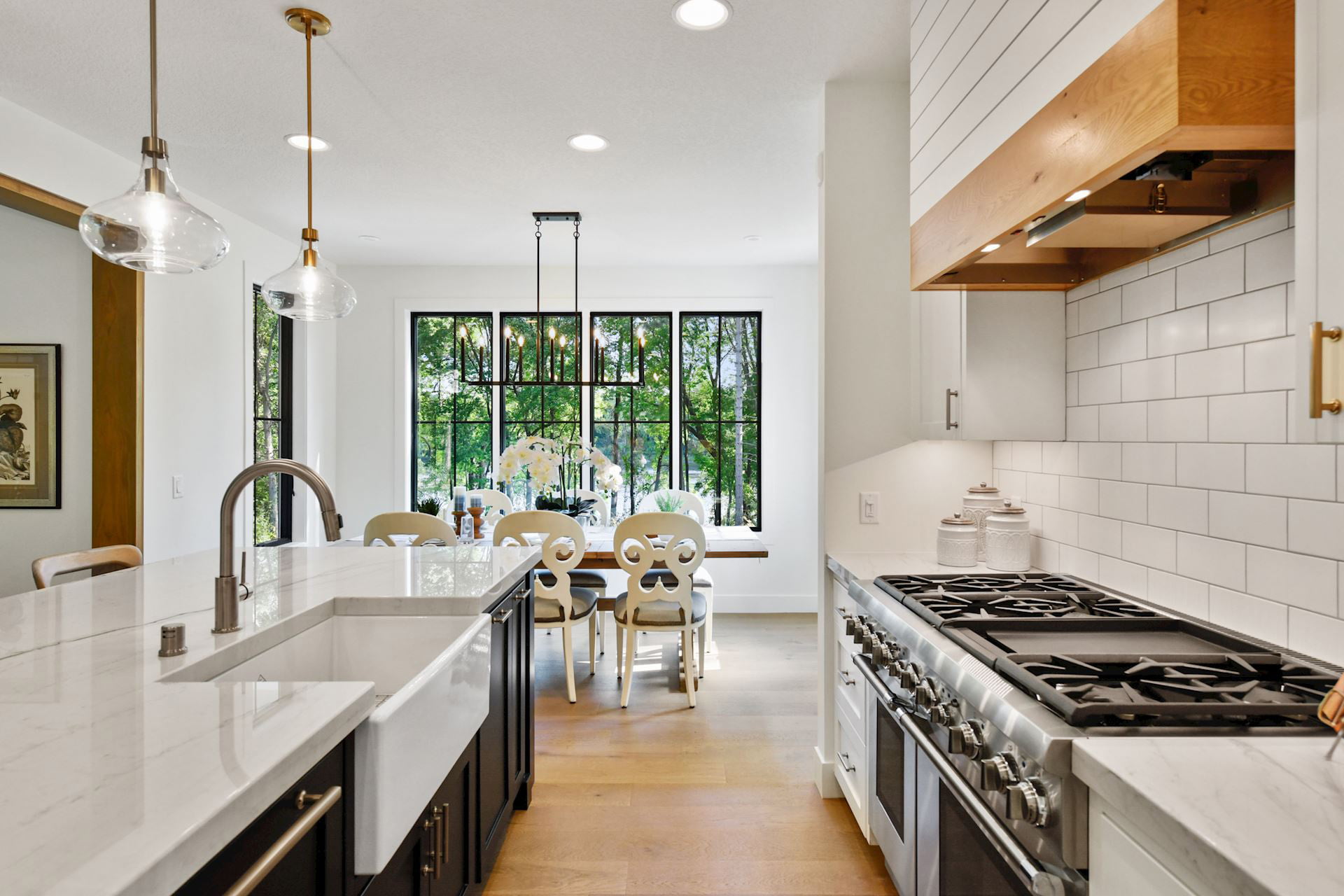 Kitchen with white cabinets and contrasting black cabinets on the island. Light countertops with grey veining.